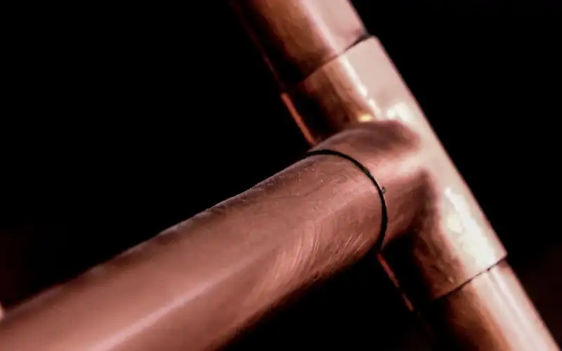 Close-up of copper pipes and fittings against a dark background