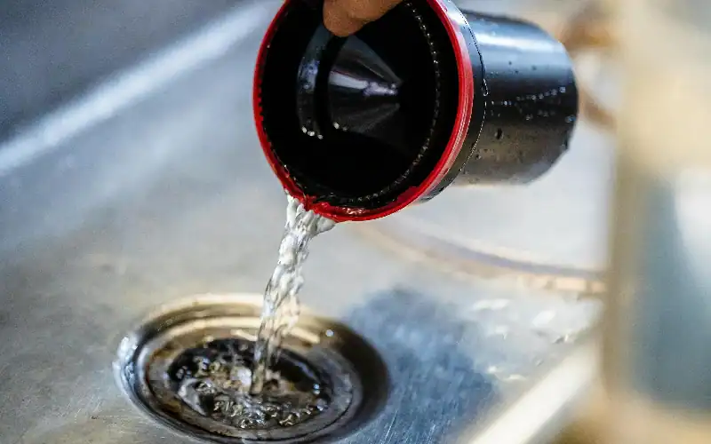 Pouring hot water into drain