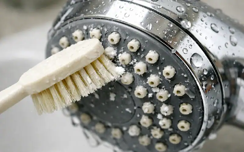 cleaning showerhead with toothbrush