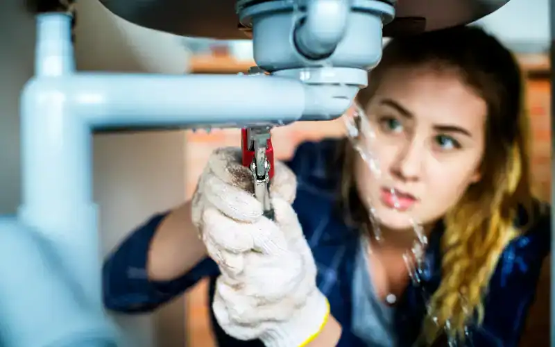 woman trying to fix leak